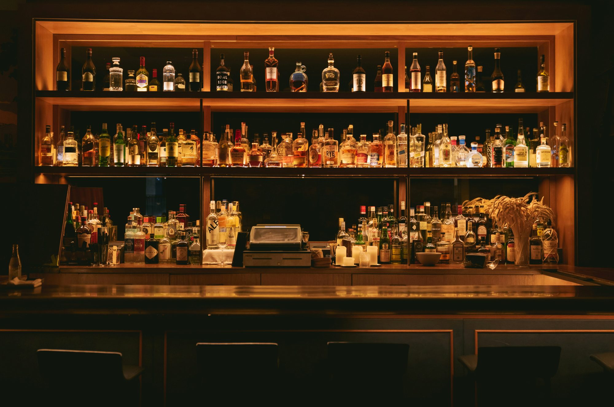 A back bar glowing amber with rows of bottles