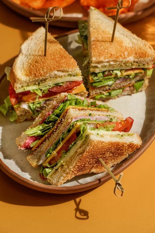 A halved club sandwich with toothpicks on a plate