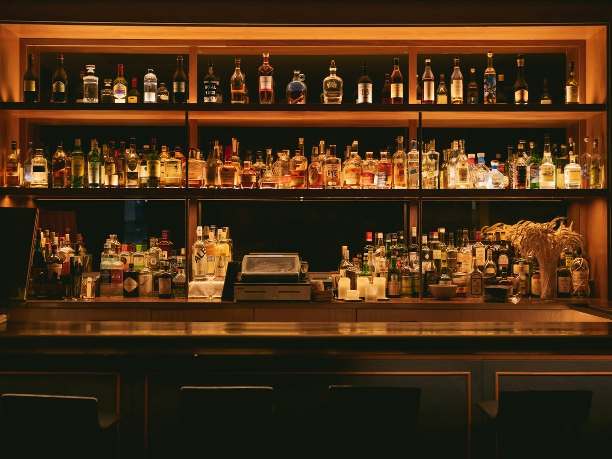 A back bar glowing amber with rows of bottles