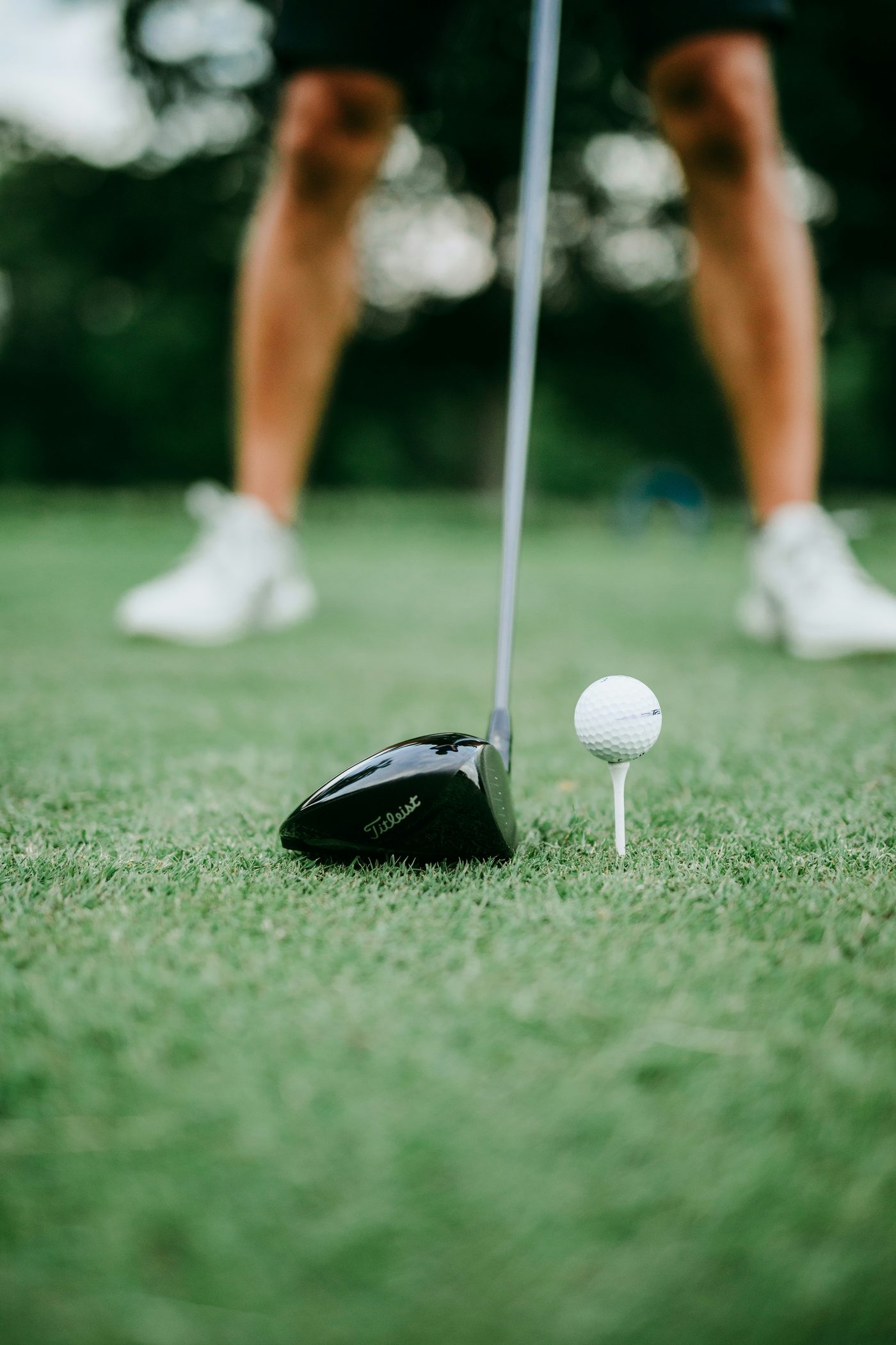 A driver and a ball on a tee, from the golfer’s feet